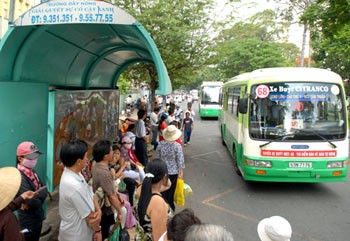 Commuters waiting at a bus-stop in HCMC (Photo: SGGP)